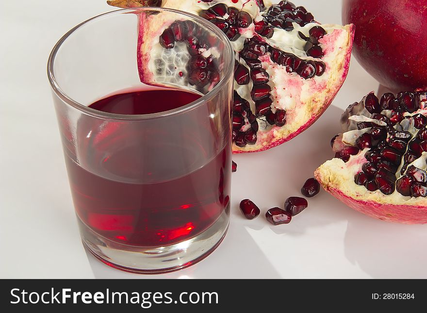 Tasty ripe pomegranate on a white background. Juice.