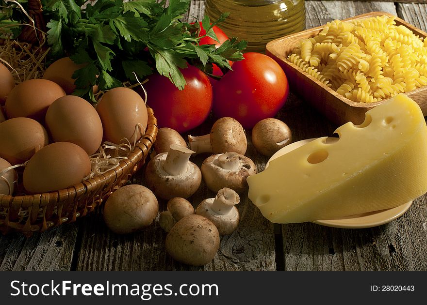 Composition of pasta, tomatoes, cheese, olive oil and mushrooms close-up. Composition of pasta, tomatoes, cheese, olive oil and mushrooms close-up.