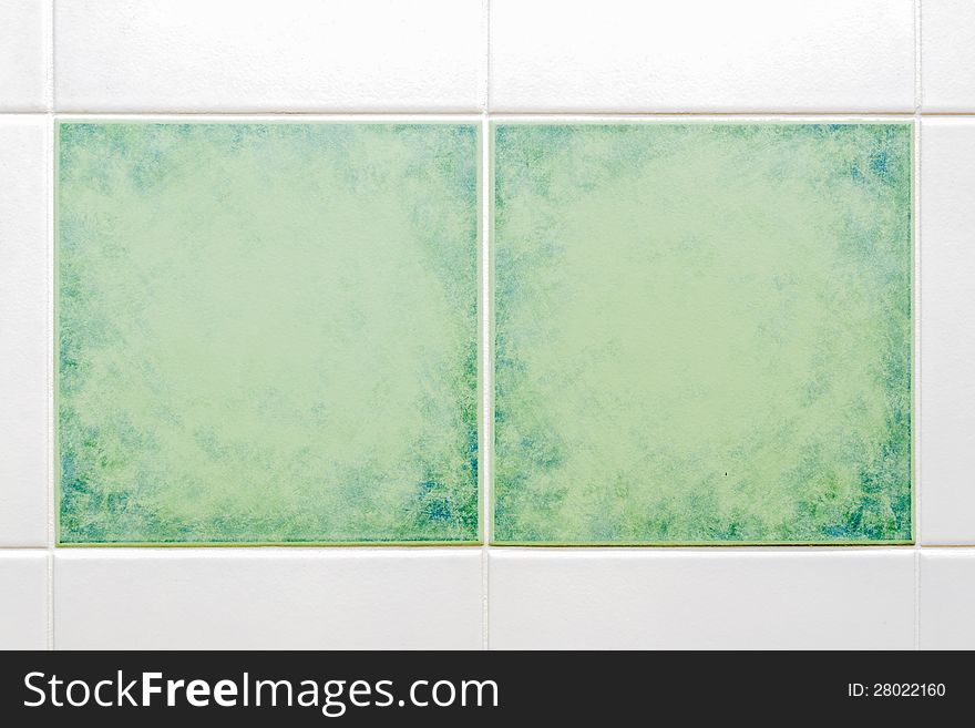 Two square green tiles with white tiles around