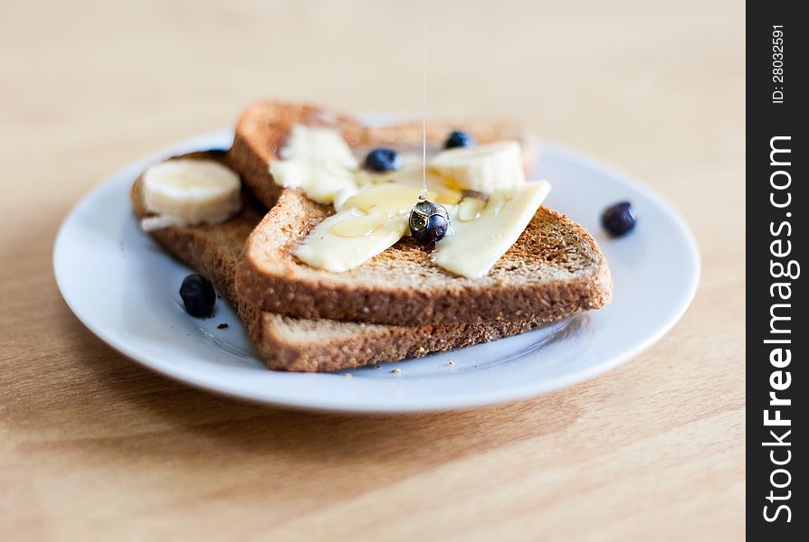 Breakfast plate with toast, butter, blueberries and honey. Breakfast plate with toast, butter, blueberries and honey