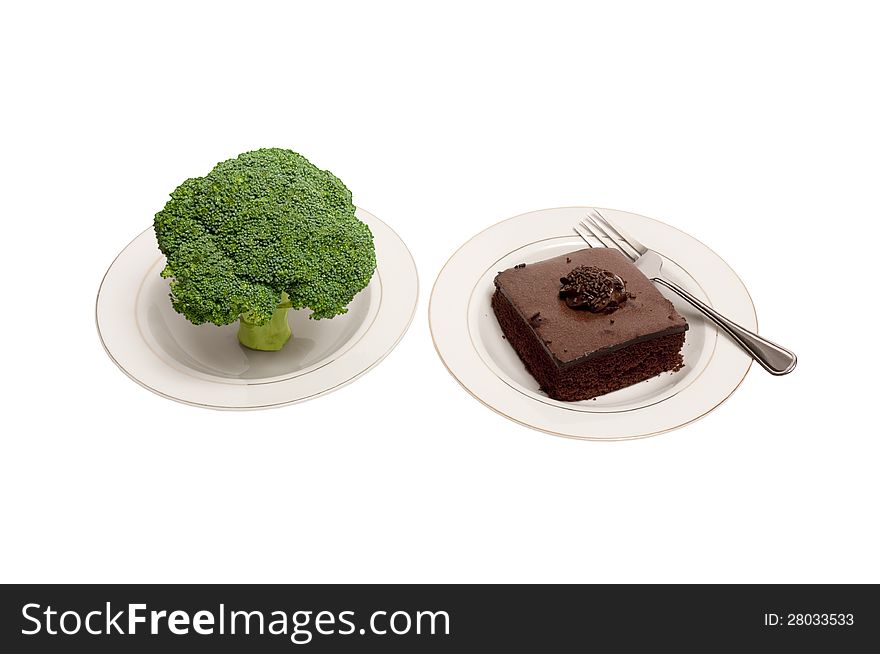 A large stalk of broccoli and a piece of chocolate cake on white plates with a fork.  Gives you a choice of healthy food or unhealthy food. A large stalk of broccoli and a piece of chocolate cake on white plates with a fork.  Gives you a choice of healthy food or unhealthy food.