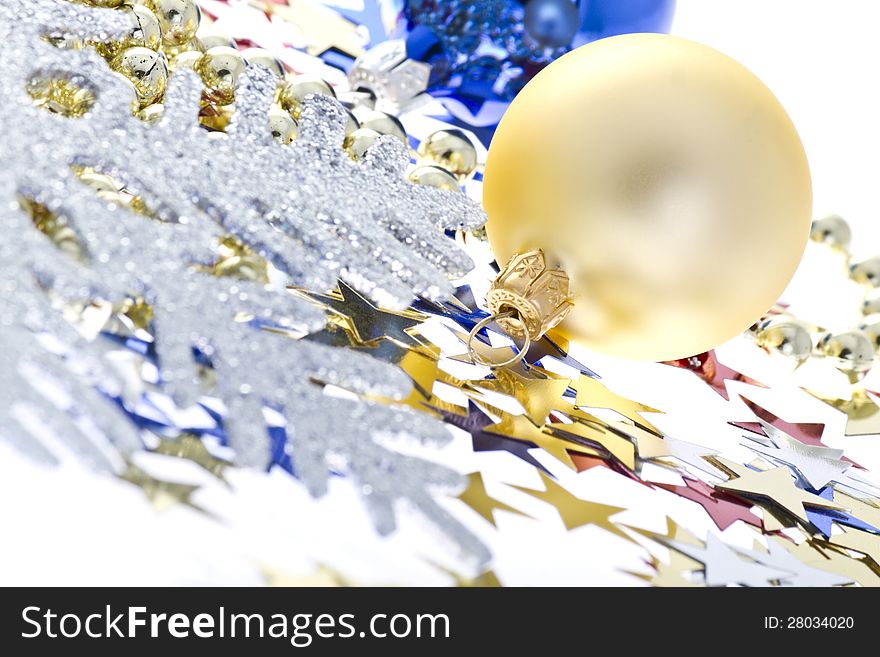 Christmas decoration collage on a white background with a decorative silver snowflake, colorful confetti in a star shape and Christmas balls.