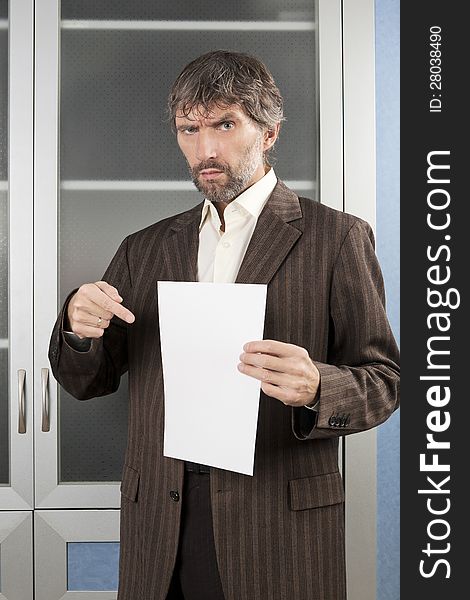 Angry man in business suit shows blanc sheet of paper. Angry man in business suit shows blanc sheet of paper