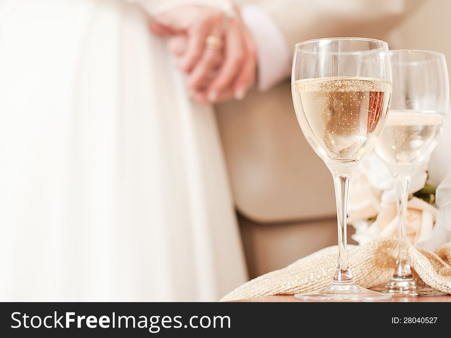 Bride and groom are holding hands, sparkling champagne glasses