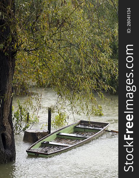 Wooden rowboat under heavy rain.