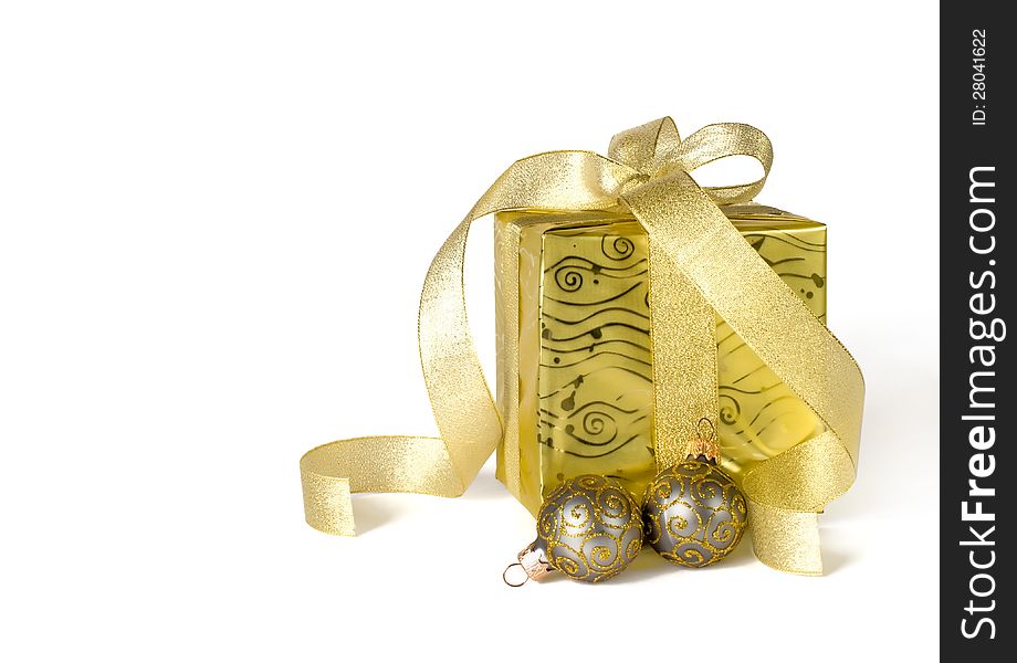 Golden gifts box with brocade ribbon and Christmas balls isolated on white. Golden gifts box with brocade ribbon and Christmas balls isolated on white