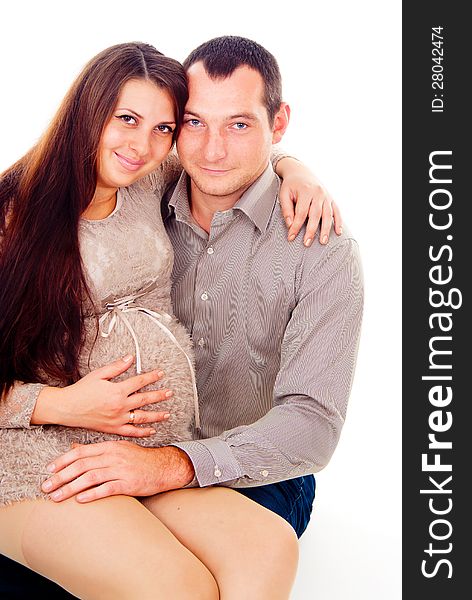 Dad keeps his pregnant wife on her knees isolated on white background