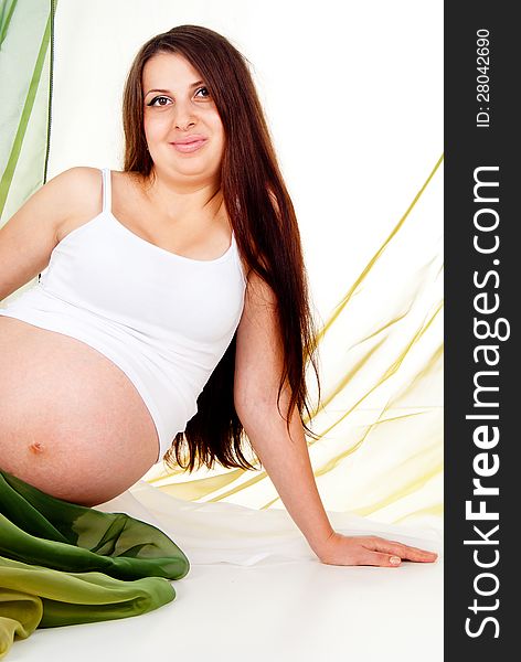 A pregnant girl in a green veil isolated on white background