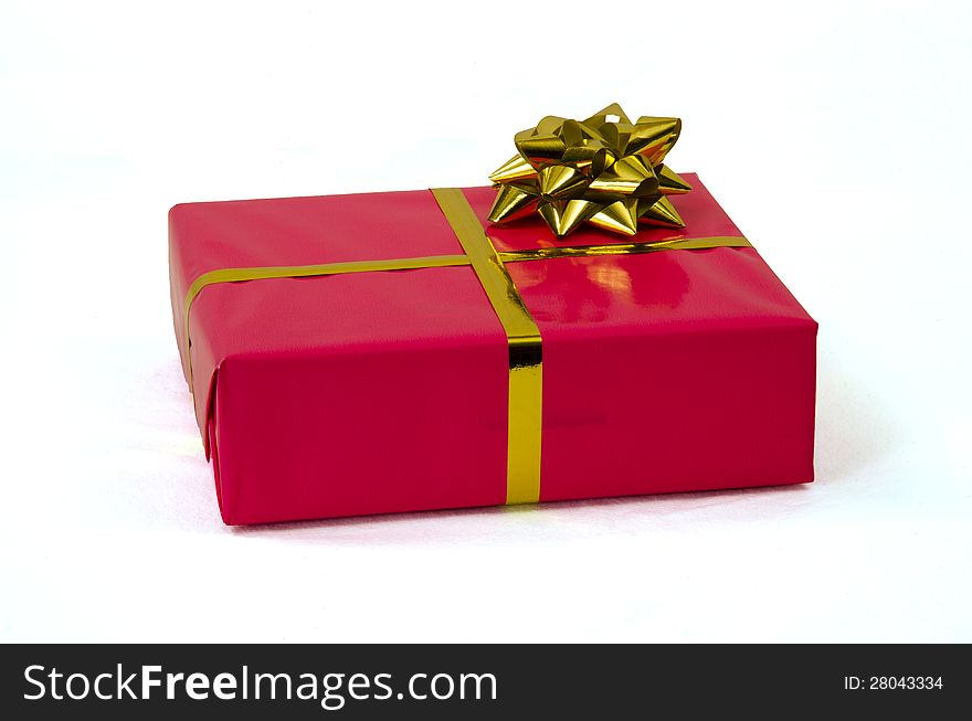 One single present packed in pink wrapping paper and  a ribbon isolated on white