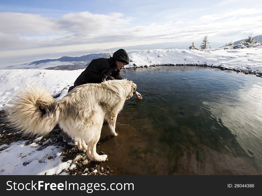 Woman with her dog in snowy mountain scenery