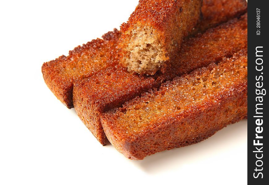 Three and half roasted croutons closeup on a white background