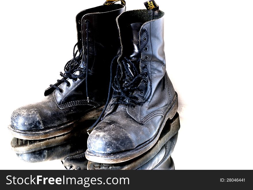 Pair of used safety boots over a mirror. Pair of used safety boots over a mirror