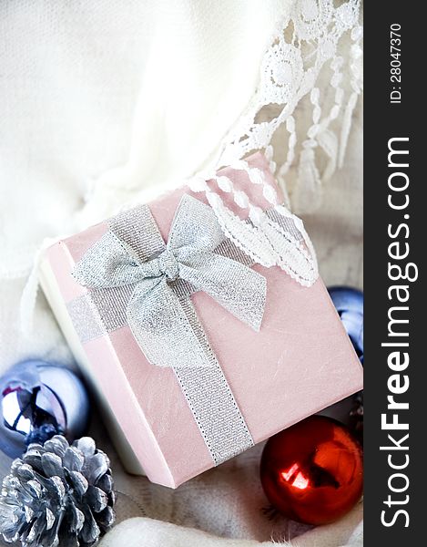 Lovely gift box put on white clothing with christmas ornament. Lovely gift box put on white clothing with christmas ornament