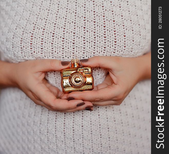 Woman's hands with manicure holding a Christmas toy golden