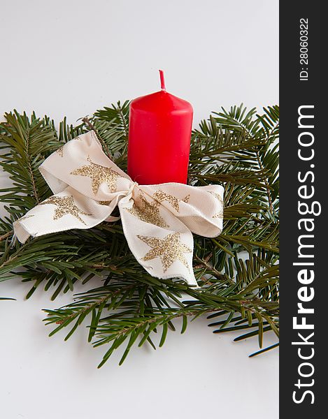 Red candle with a white golden bow on a white background