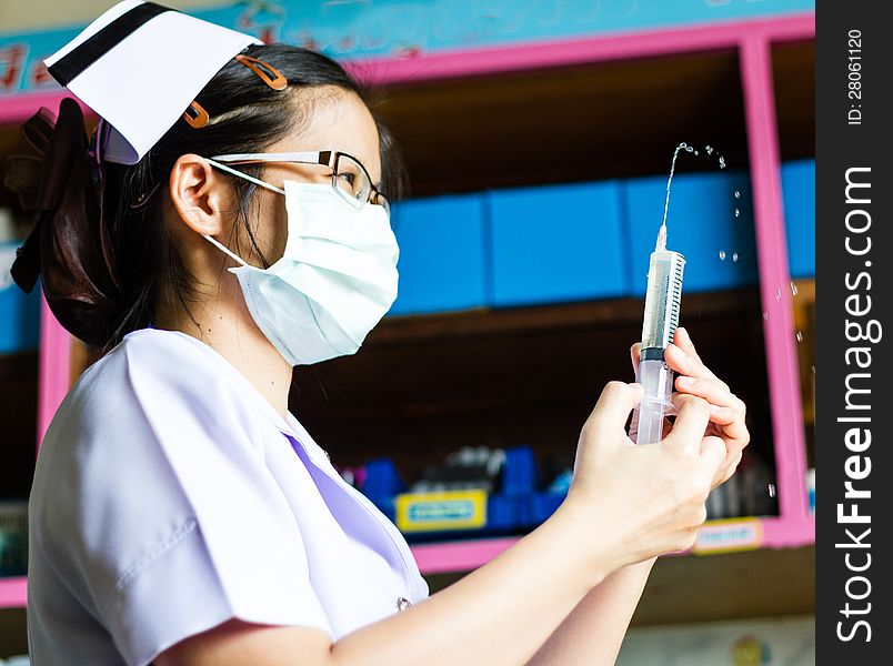 Nurse with medical syringe with needle in ampule getting ready for patient injection