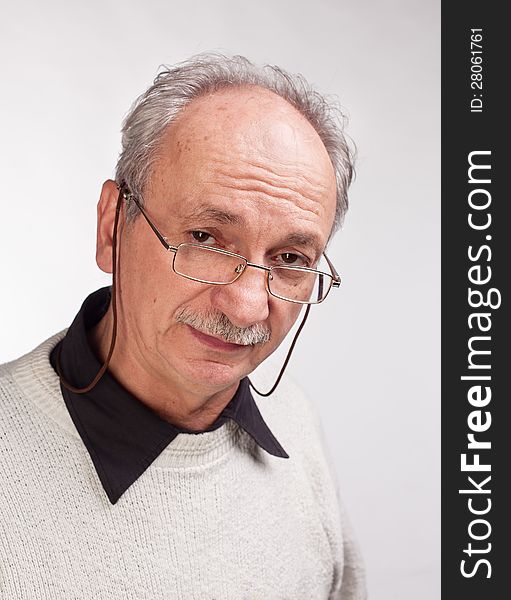 Portrait of a happy mature man with glasses and a white sweater