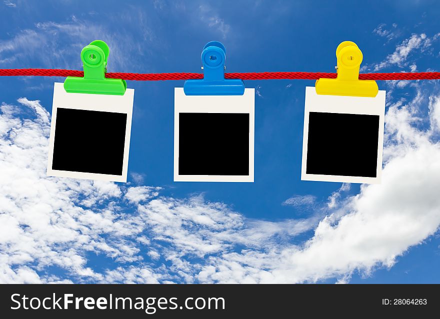 Blank photo frames Hanging by plastic peg on blue sky