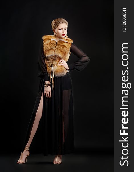 Fashionable Woman in Luxury Fur Coat over Black Background. Fashionable Woman in Luxury Fur Coat over Black Background