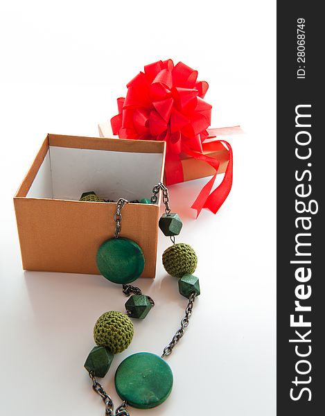 Gift box with red bow and green necklace