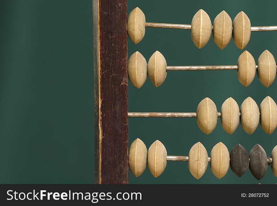 Old abacus fragment over green background