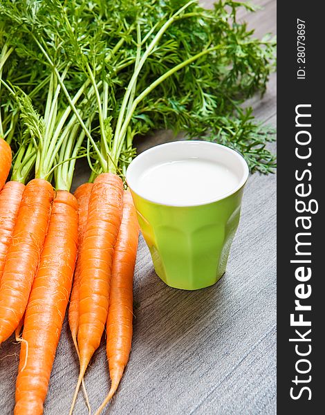 Closeup shot of fresh carrots and glass with milk