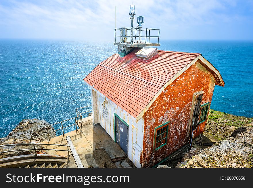 Old colorful beautiful house on the edge of the earth and the deep blue ocean behind. Old colorful beautiful house on the edge of the earth and the deep blue ocean behind