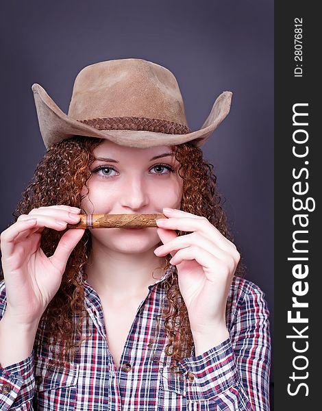 Portrait of a pretty girl with a cigar cowboy