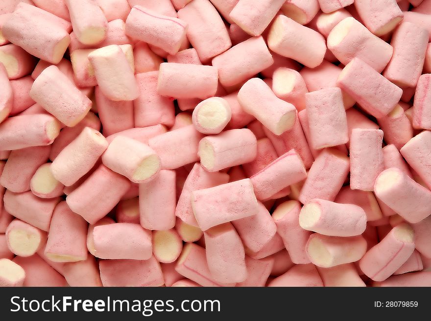 Catering background of a pile of pink and white marshmallows in rolled tubes with a spongy texture