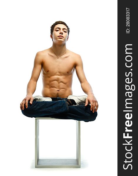 Athletic young man sitting in lotus pose  on white background
