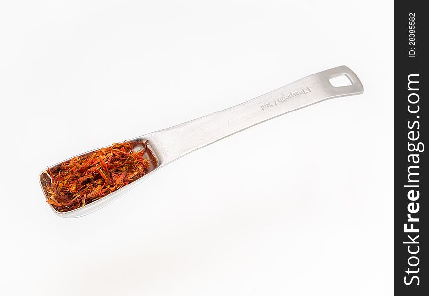 Saffron flakes dried on teaspoon measure