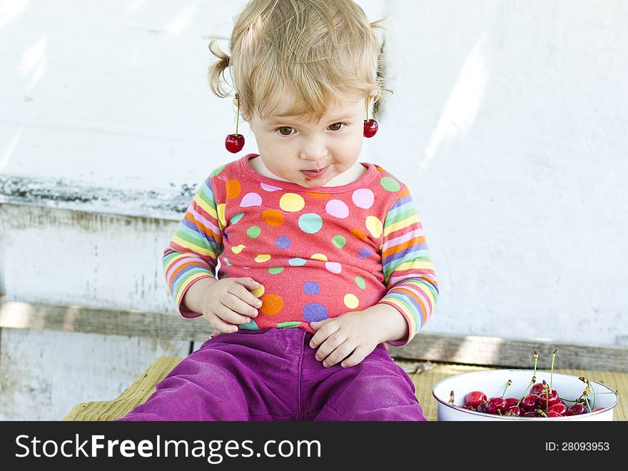 Adorable little girl with a cherry on her ear