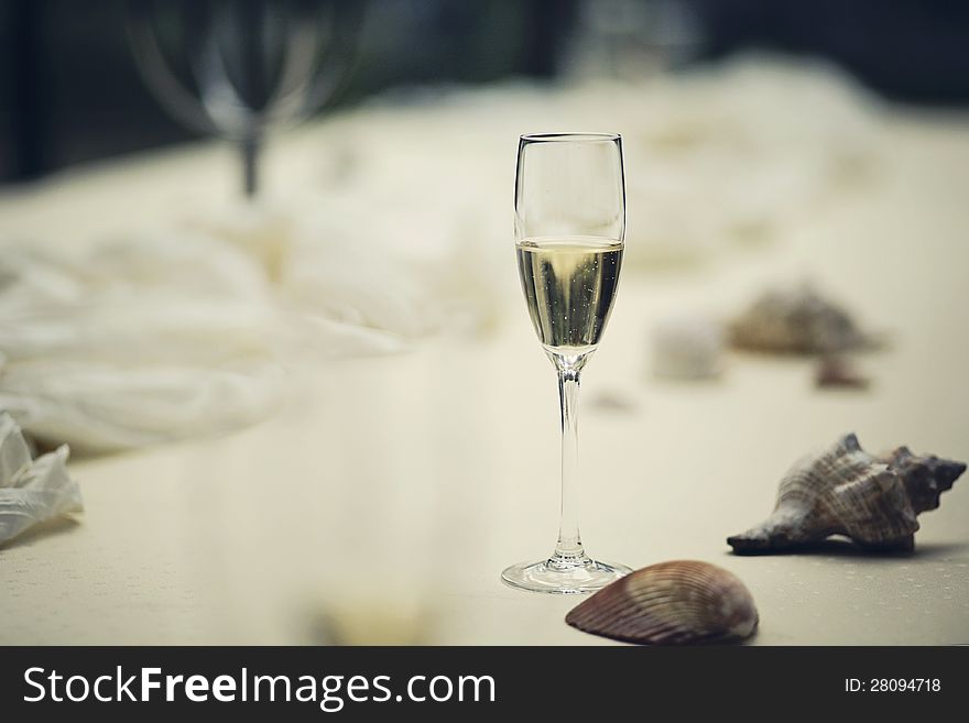 A glass of white wine on a wedding table with decorations. A glass of white wine on a wedding table with decorations