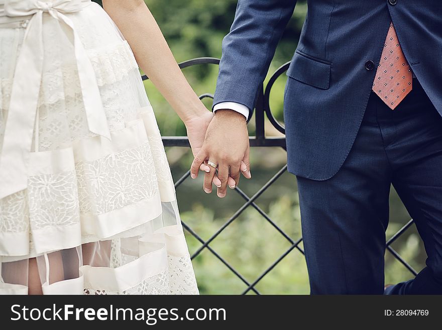 Newly weds holding hands in a park