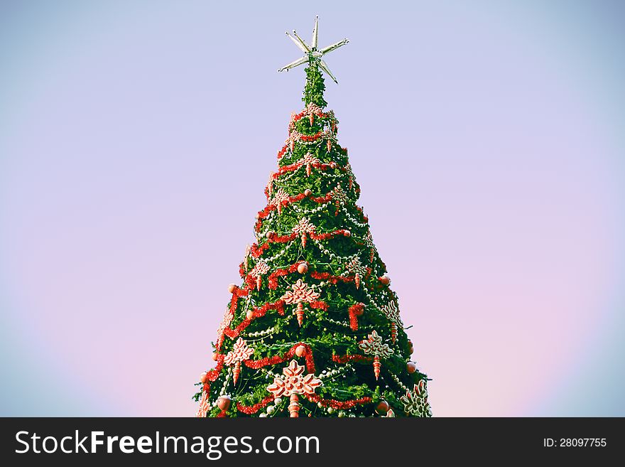 The christmas tree against abstract sky.