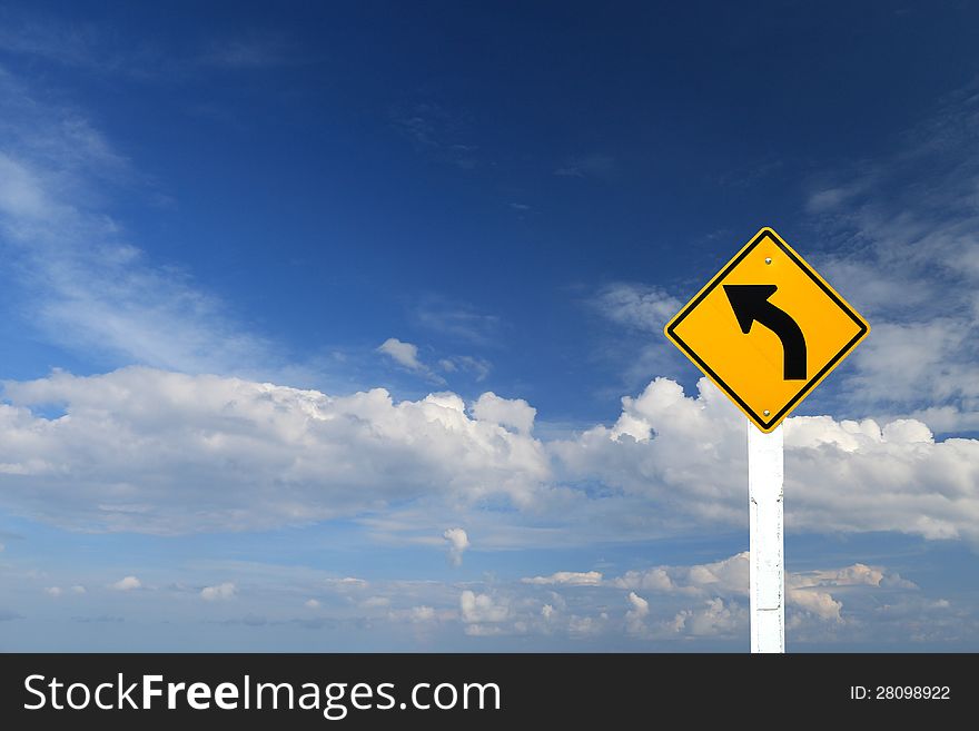 Direction sign- left turn warning on blue sky background with blank for text. Direction sign- left turn warning on blue sky background with blank for text