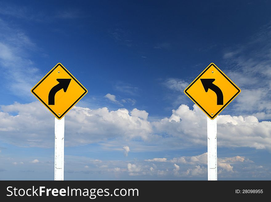 Direction sign- left and right turn warning on blue sky background with blank for text. Direction sign- left and right turn warning on blue sky background with blank for text