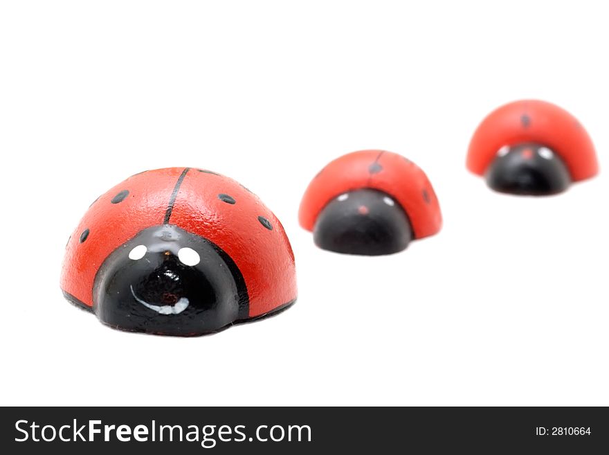 Three  toy ladybugs  isolated on white (diminishing perspective)