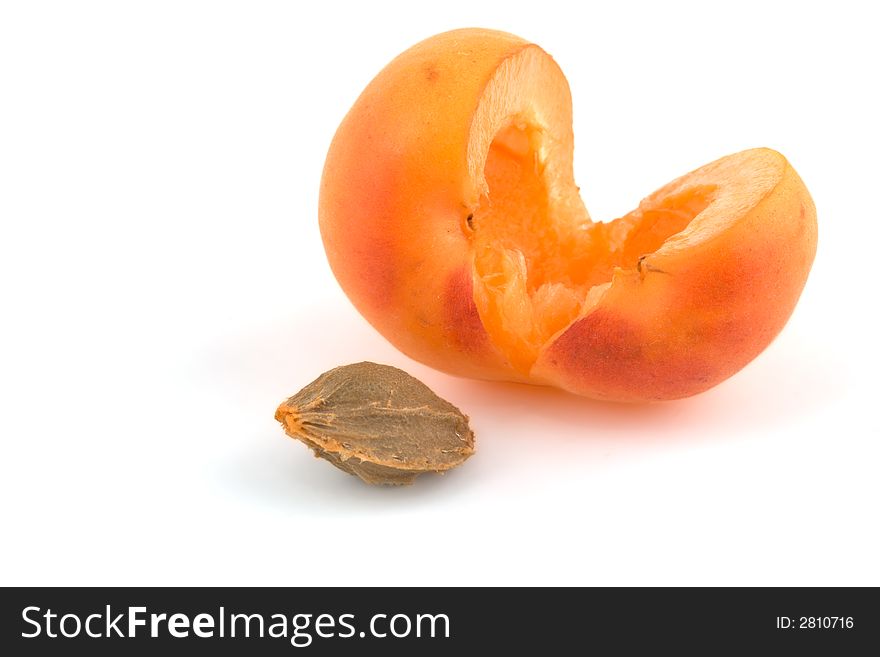 Apricot with extracted stone laying nearby. Apricot with extracted stone laying nearby