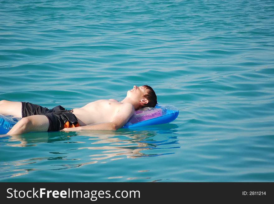 Boy is relaxing at the pool. Boy is relaxing at the pool