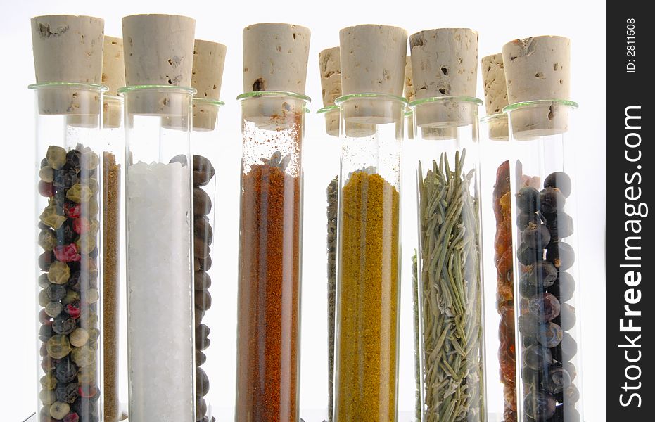 Spices in test tubes in front of a white background
