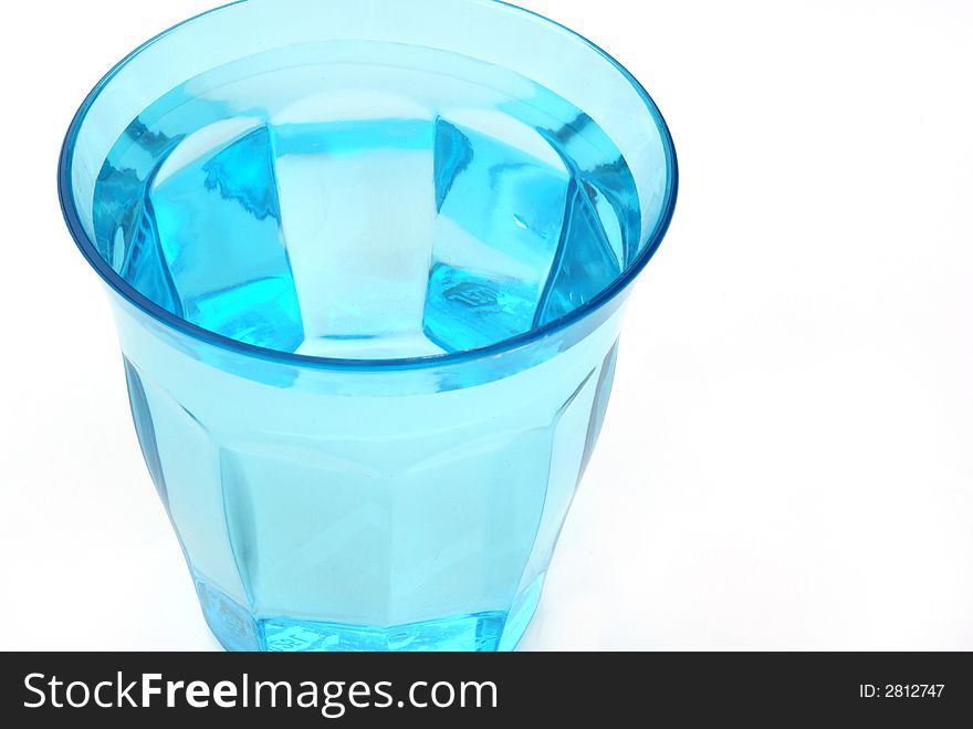 A blue glass of water against white background. A blue glass of water against white background.