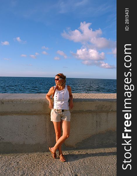 Young girl wearing sunglasses against blue sky. Young girl wearing sunglasses against blue sky