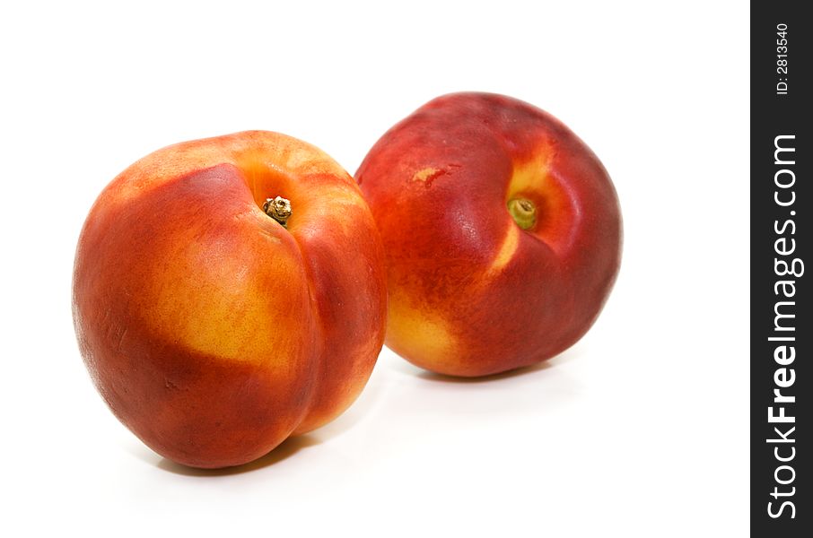 A pair of luscious sun-ripened nectarines on a white background. A pair of luscious sun-ripened nectarines on a white background