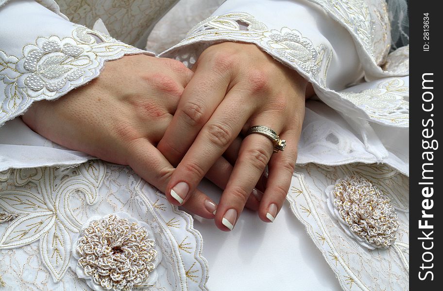The Bride's Hands layed on the dress showing the ring