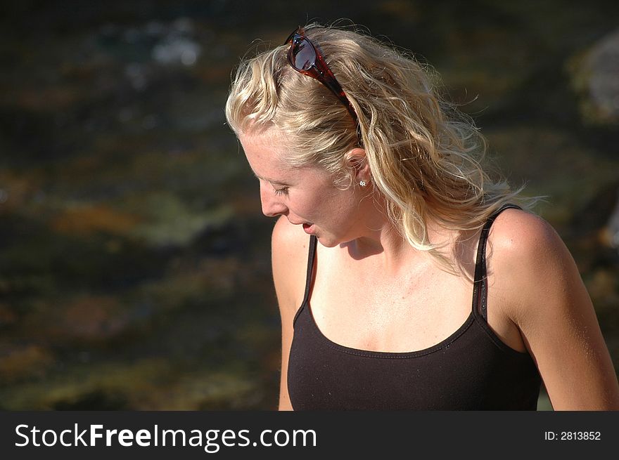 A profile of a pretty young blond woman standing near a river. A profile of a pretty young blond woman standing near a river.