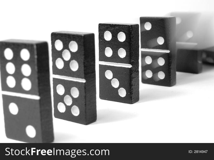 Black domino blocks in line, one is falling. Black domino blocks in line, one is falling