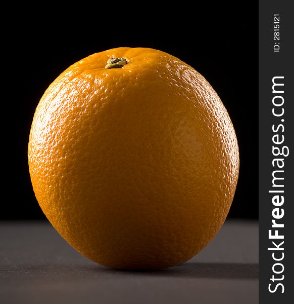 Single orange with a black background