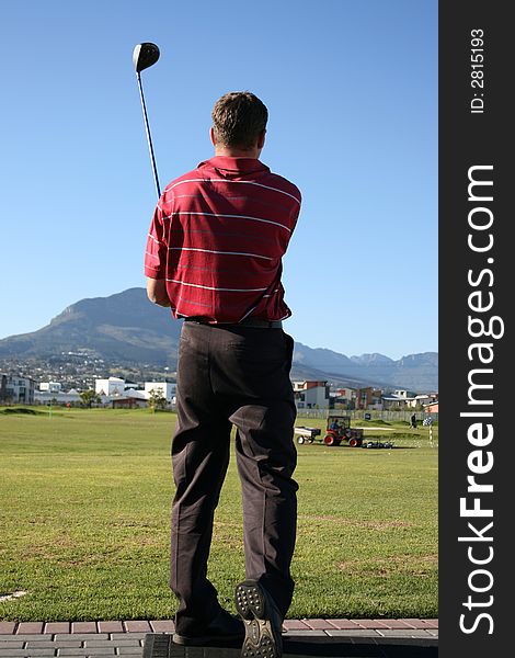 Young golfer following his golf shot on the range