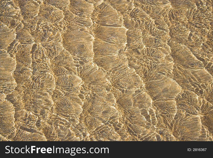 Light reflecting off the low tide rippling over a sandy beach. Light reflecting off the low tide rippling over a sandy beach.